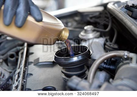 From Cans Of Oil Pouring Oil In Car Engine
