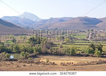 Looking Towards Nieu-bathesda With Green Fields In Foreground