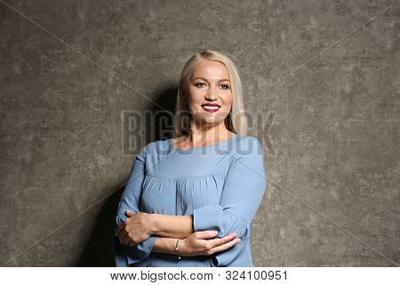 Portrait Of Beautiful Mature Woman On Grey Background