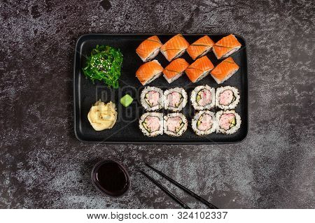 Sushi Set Of Maki Rolls With Wakame Salad Served On Stone Plate. Japanese Food. Top View