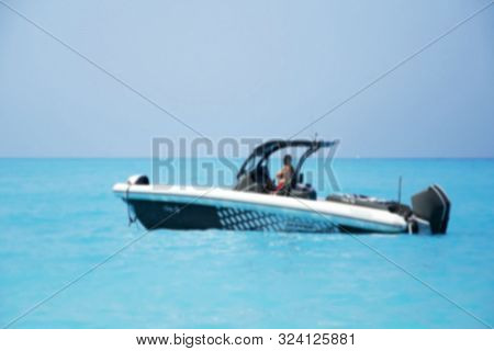 Blurred Private Small Speedboat Moored On The Shore In Lefkada Island, Greece. Blue Sea.