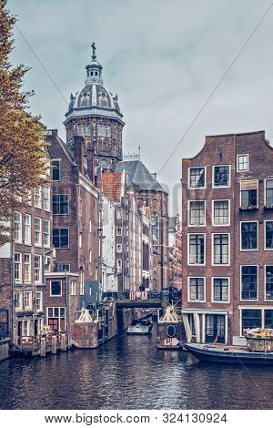 Bicycles in Amsterdam street near canal with old houses. Amsterdam, Netherlands