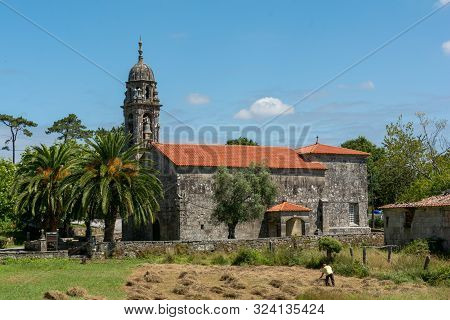 The Man Rakes The Hay In Front Of Church Of Santa Marina De Carracedo On Camino De Santiago