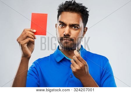 sport, caution, game and football concept - indian male referee with whistle and showing red penalty card