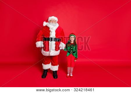 Full Size Photo Of Cheerful Two Santa And Elf Holding Hands Ready To Enjoy Newyear Noel Wearing Brig