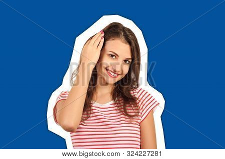Close Up Picture Of A Young Beautiful Woman Fixing Her Hair While Looking At The Camera. Emotional G