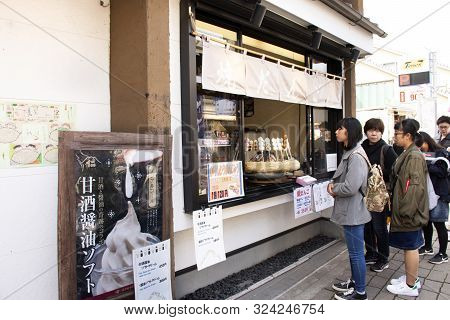 Japanese People And Foreign Traveler Stand Waiting Line Up For Buy Dango Or Japanese Dumpling And Sw