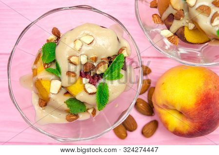 Baked Peaches Dessert In An Ice-cream Bowl Topped Sabayon Cream With Almond And Mint Against The Pin