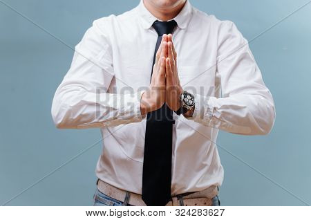 Businessman In White Shirt Joining His Hands, Making Prayer Gesture Over Blue