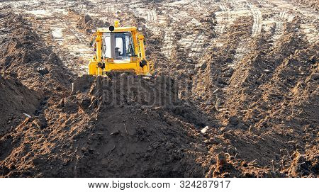 Tractor Bulldozer Removes Top Layer Of Fertile Soil Overburden Forest, Grass, Harvesting Site For Op