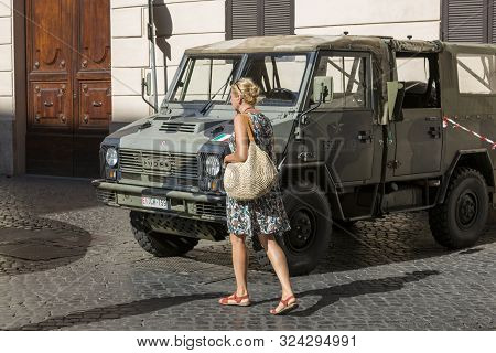 Rome, Italy - August 16, 2019: A Woman Walks Near The Car Anti-terrorism Military Patrol On A Street