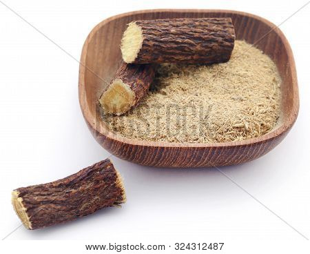 Liquorice Stick And Ground In A Bowl Over White