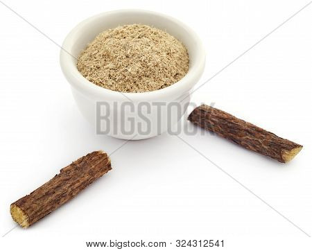 Liquorice With Powder In A Bowl Over White
