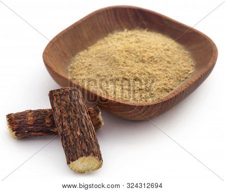 Liquorice Stick And Ground Powder In A Bowl Over White