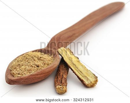 Liquorice Stick And Ground Powder In A Spoon Over White Background
