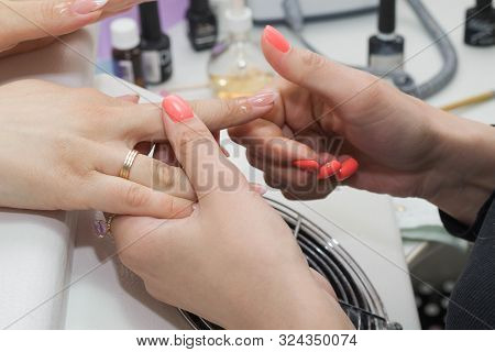 The Nail Technician Rubs The Oil On The Clients Hand.