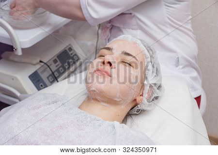Applying Foam To The Face Of The Girl Before The Mesotherapy Procedure