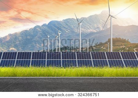 Asphalt Road With Solar Panels With Wind Turbines Against Mountanis Landscape Against Sunset Sky,alt