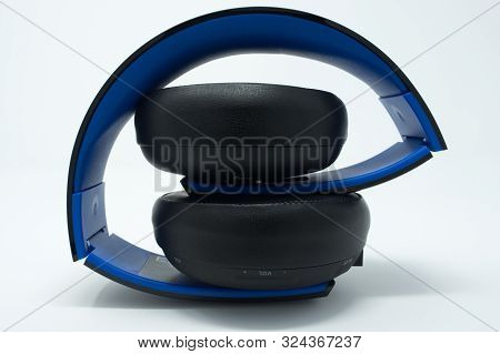 Black And Blue Folded Over The Ear Headphones. Isolated On A White Background.