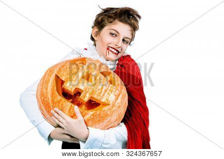 Portrait of a boy dressed in a costume of a vampire over white background. Halloween party. 