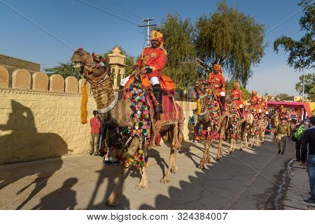 Jaisalmer, India - February 17, 2019: Ceremonial Procession Camels And Riders In Desert Festival In 