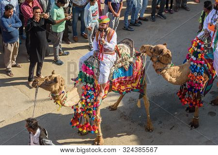 Jaisalmer, India - February 17, 2019: Ceremonial Procession Camels And Riders In Desert Festival In 