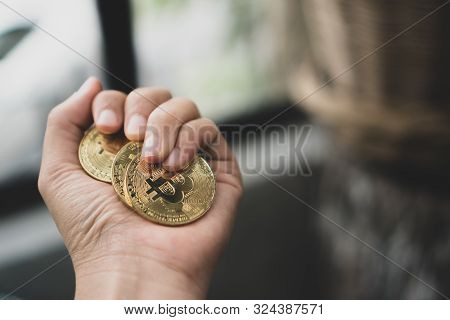 Hand Holding A Bunch Of Bitcoins As A Symbol Of Digital Money Or Cryptocurrency. Success Investment 