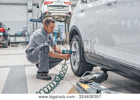 Car Repair, Bmw Advertising, Moscow, 1.11.2018: Car Repair: Wheel Replacement Closeup. Mechanic Scre