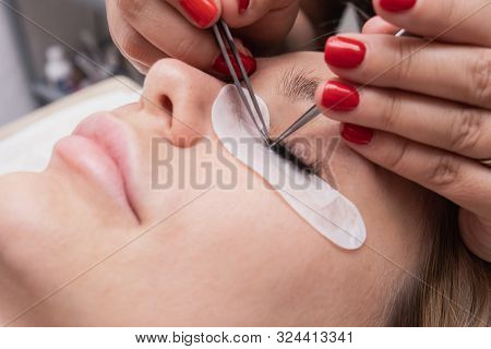 Beauty Saloon. Close-up, Procedure For Eyelash Extension. The Master Glues Each Cilium With Special 