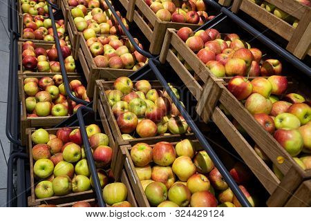 Diagonal View Of Wooden Lug Boxes With Apple Crop On Counter In Store
