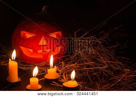 Helloween Pumpkin With Candles  On Black Background. Big Spooky Helloween Symbol. Selective Focus