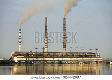 Thermal Power Station Tall Pipes With Thick Smoke Reflected In Lke Water Surface. Pollution Of Envir