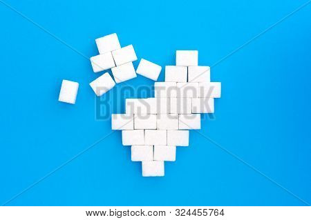 Broken Heart From Sugar Cubes, Blue Background. The Concept Of Problems Associated With High Blood S