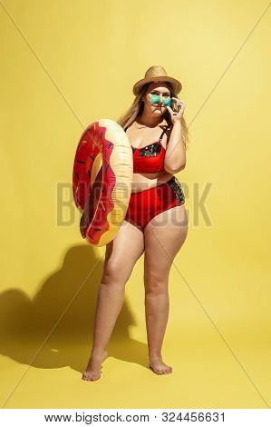 Young Caucasian Plus Size Female Models Preparing For Beach Resort On Yellow Background. Woman In Re