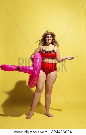 Young Caucasian Plus Size Female Models Preparing For Beach Resort On Yellow Background. Woman In Re