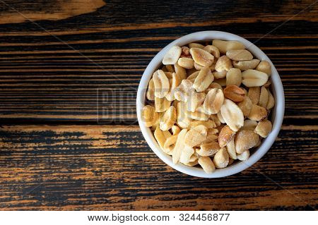 Salted Peanuts In Bowl On Wooden Background. Delicious Peanuts Containing Vitamins And Amino Acids: 