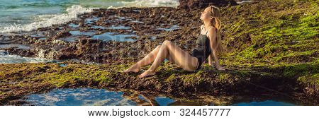 Young Woman Tourist On Pantai Tegal Wangi Beach Sitting In A Bath Of Sea Water, Bali Island, Indones