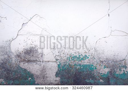 Old White Dusty Brick Wall With Cracks And Moss Structure, Covered With Stucco And Green Paint. Colo