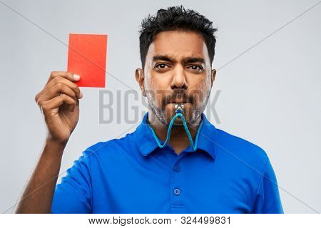 sport, caution, game and football concept - indian referee whistling and showing red penalty card