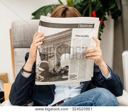 Paris, France - Sep 27, 2019: Woman Reading French Press In Living Room Newspaper Following The Deat