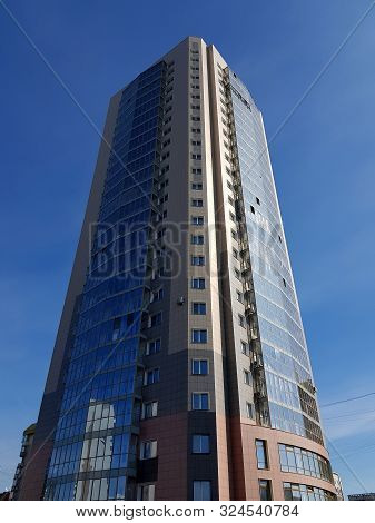 Novokuznetsk, Russia - 09.27.2019. High-rise Building Against The Blue Sky, Bottom View In Perspecti