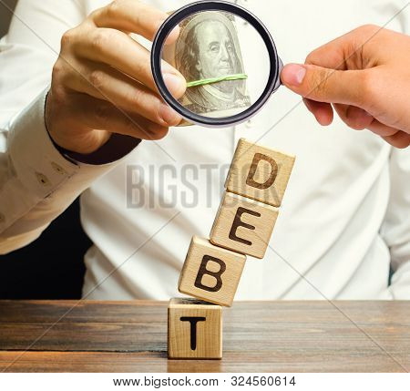 Businessman Removes Wooden Blocks With The Word Debt. Debt Relief Or Cancellation Is The Partial Or 