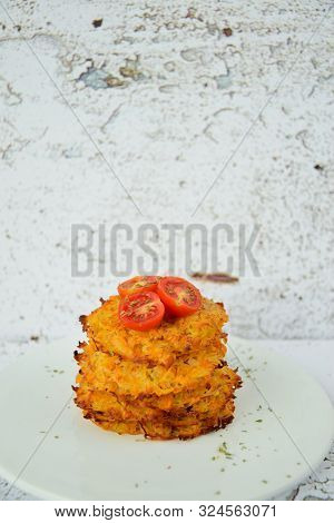 Hash Browns Or Potato Pancakes Or Swiss Rösti Garnish With Cherry Tomato And Parsley