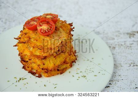 Hash Browns Or Potato Pancakes Or Swiss Rösti Garnish With Cherry Tomato And Parsley