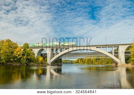 Kouvola, Finland - 25 September, 2019: Autumn Landscape Of Bridge With Moving Passenger Train And Ky