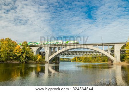 Kouvola, Finland - 25 September, 2019: Autumn Landscape Of Bridge With Moving Passenger Train And Ky