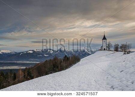 Panoramic View At St. Primus And Felician Church In Jamnik, Julian Alps, Slovenia
