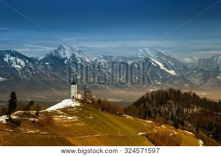 Panoramic View At St. Primus And Felician Church In Jamnik, Julian Alps, Slovenia