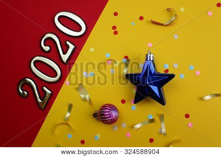 On A Red And Yellow Background Are Laid Out The Numbers 2020 With Confetti And Christmas Toys