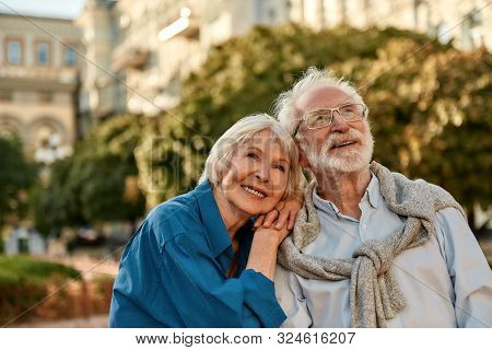 Endless Love. Portrait Of Beautiful Senior Woman Leaning At Shoulder Of Her Husband And Smiling Whil